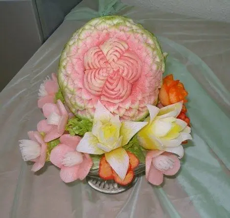 A decorative pattern being carved into a watermelon