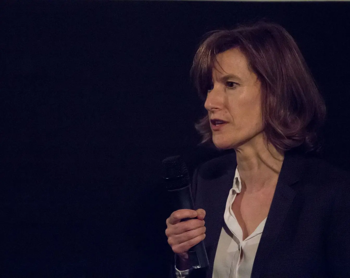 Film director Joanna Hogg, as identified in the source file, speaking with a microphone on a darkened stage at a film event. File photograph from an earlier appearance, not from the El Gouna festival.