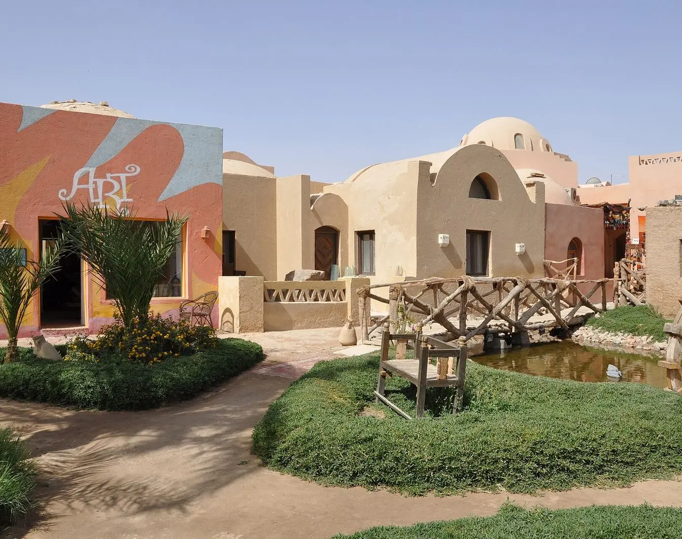 File photo of El Gouna: domed sand- and ochre-coloured resort buildings with an art gallery, planted gardens and a wooden footbridge over a small waterway. Not a photograph taken during the film festival.
