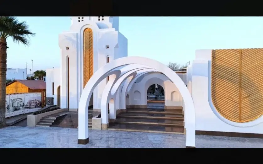 Arched white entrance canopy and steps leading into a hotel arrival area in Hurghada, framed by palm trees at dusk; published alongside the renovation announcement for the Mercure Hurghada.