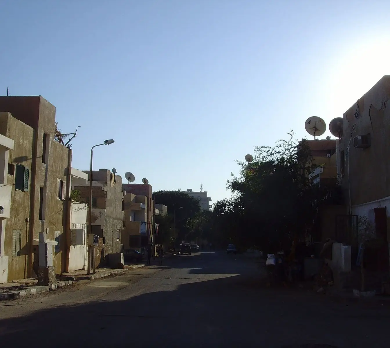 A residential street away from the tourist areas of Hurghada, with low-rise apartment blocks and parked cars