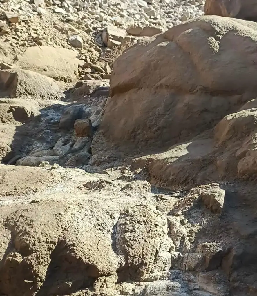 Water running between large sandstone boulders on a bare rocky slope in the mountains near Safaga, at the spring local people call Al-Maglah.