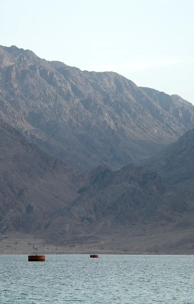 Rugged coastal mountains meeting the calm blue water of the Red Sea near Nuweiba, Sinai, Egypt.