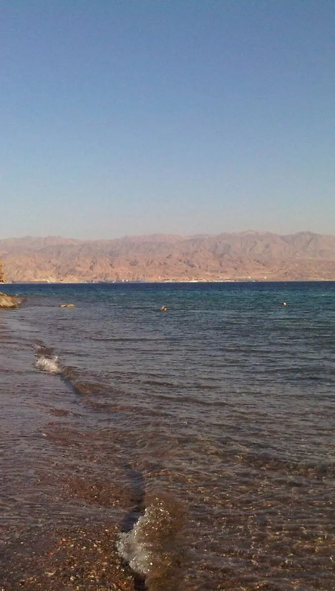 Stony beach along the Red Sea coast at Taba, Egypt, with calm blue water