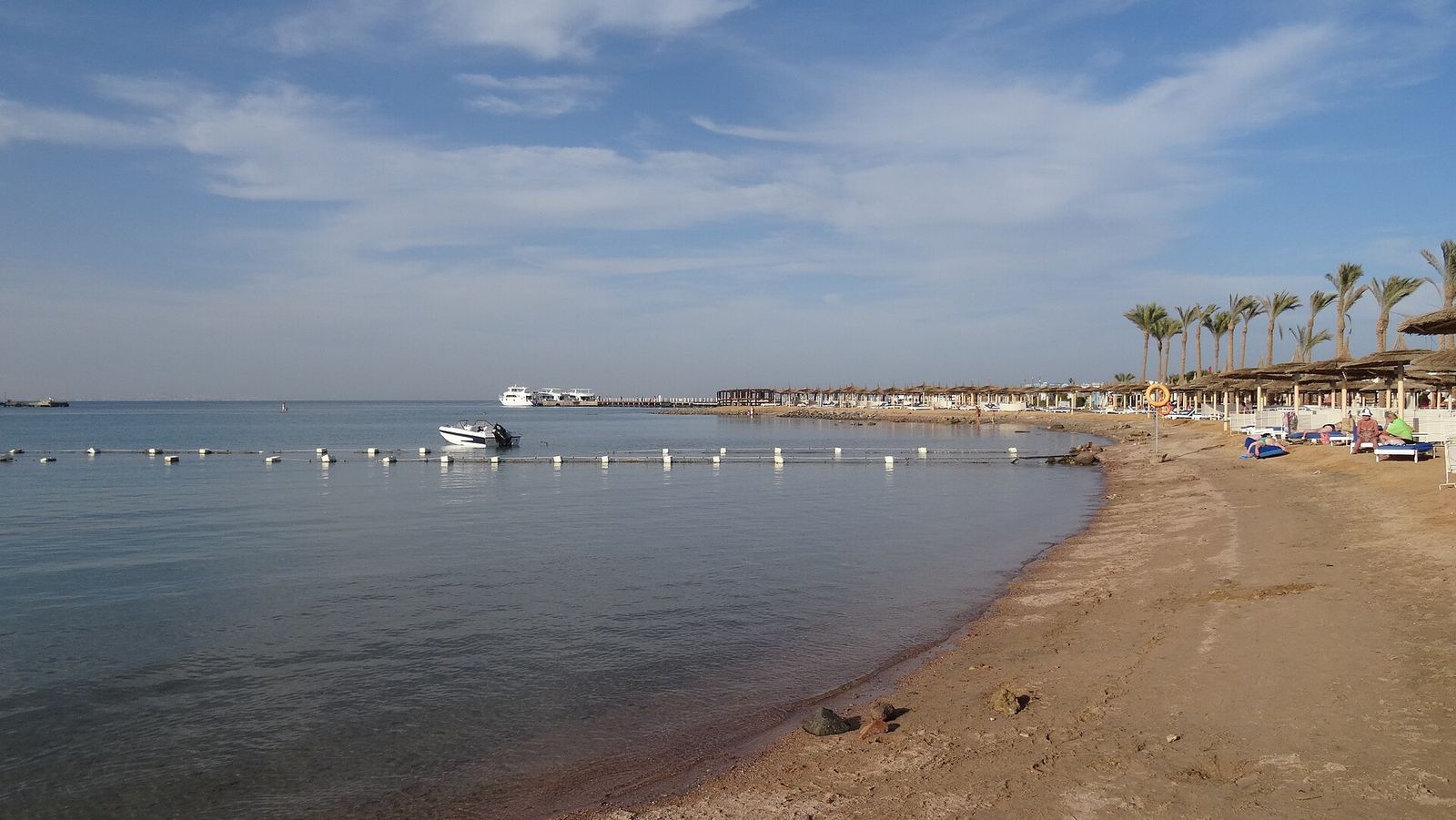 A quiet Red Sea beach with calm turquoise water along the shore